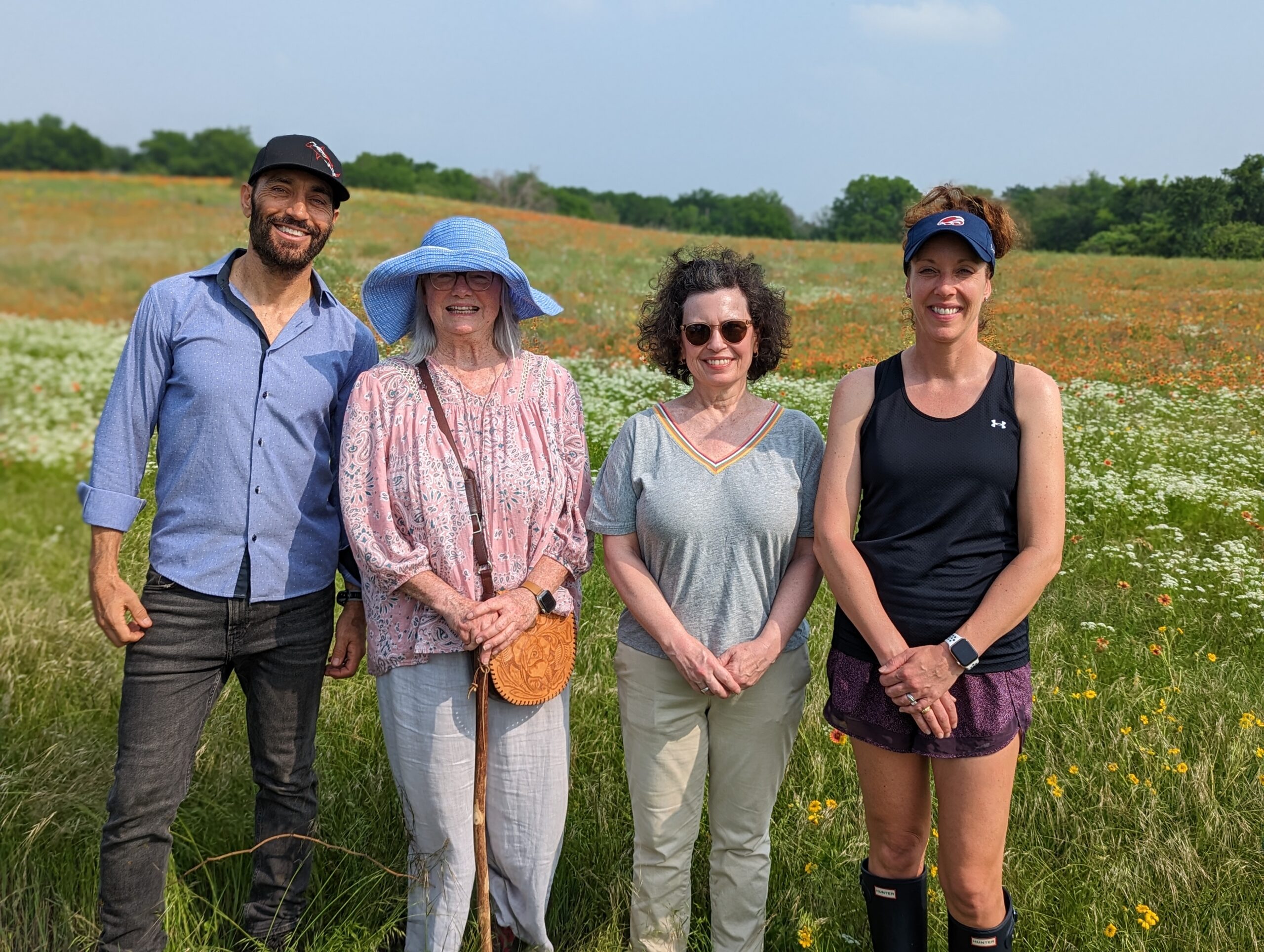 Group photo of 1 man and 3 woman standing in a field